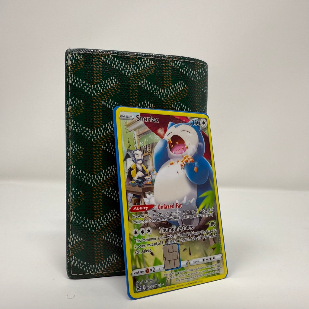 Card holder displaying a Snorlax credit card sticker with playful Pokémon art, photographed on a white background, product by Kibakiba.co
