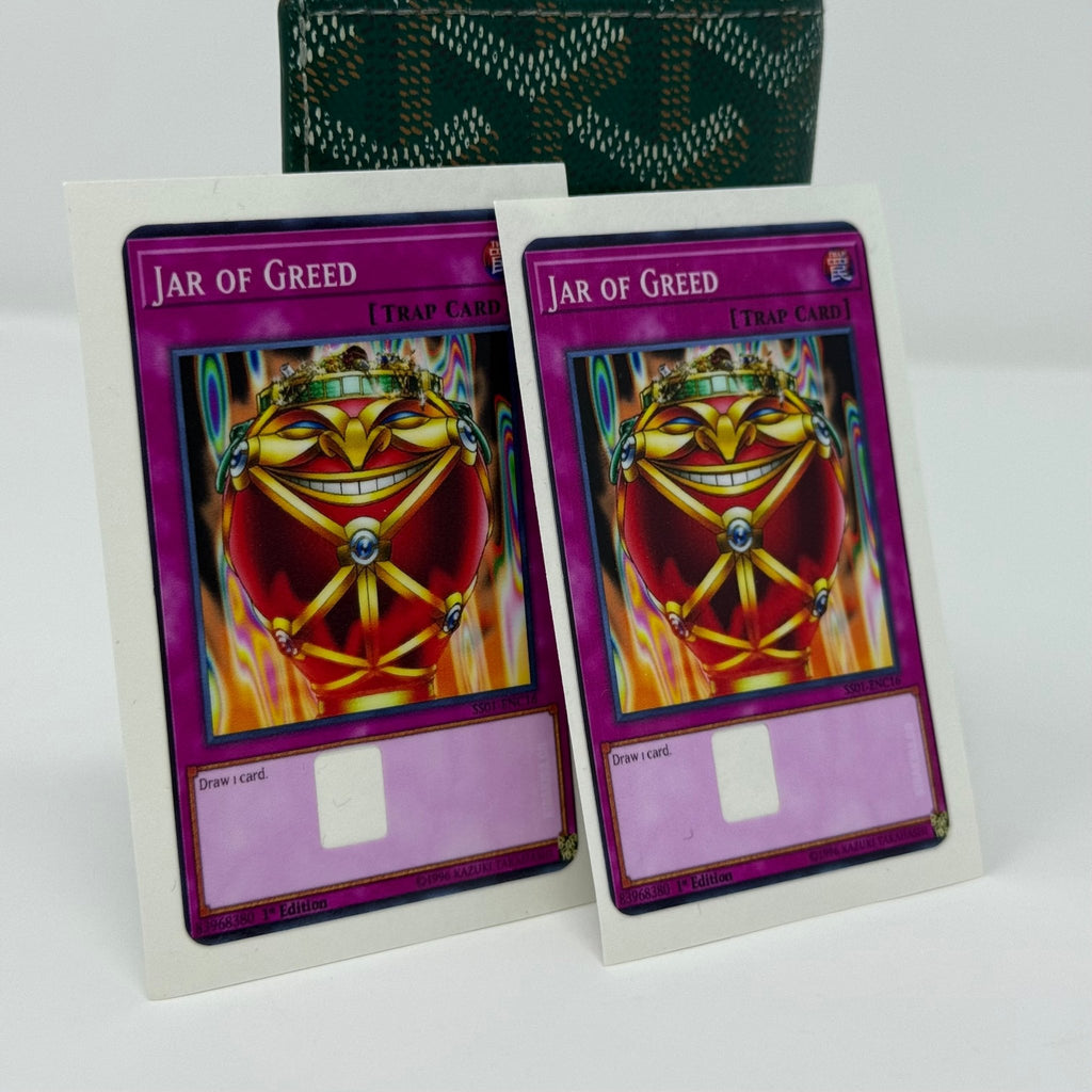 Set of two identical Jar of Greed Yu-Gi-Oh! credit card stickers displayed side by side against green patterned wallet, showing sinister smiling jar bound with golden chains on purple trap card background from Kibakiba.co
