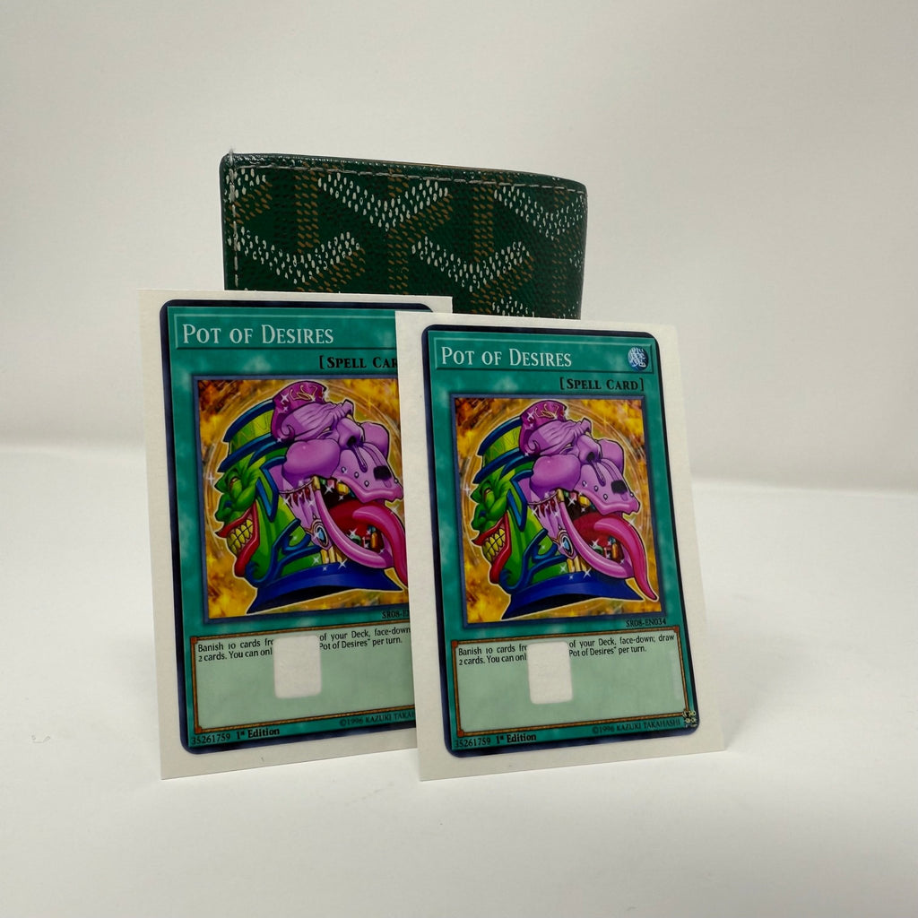 Single Pot of Desires Yu-Gi-Oh! credit card sticker displayed against green patterned wallet, showing the purple demon spell card design with teal background and detailed artwork from Kibakiba.co