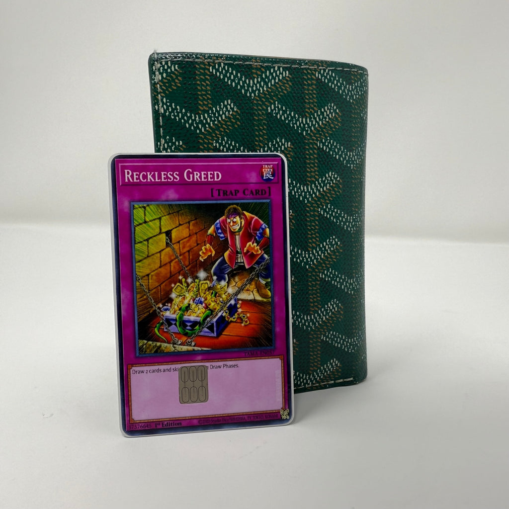 Set of two identical Reckless Greed Yu-Gi-Oh! credit card stickers displayed side by side against green patterned wallet, showing purple trap card artwork with greedy figure surrounded by golden treasure chests from Kibakiba.co